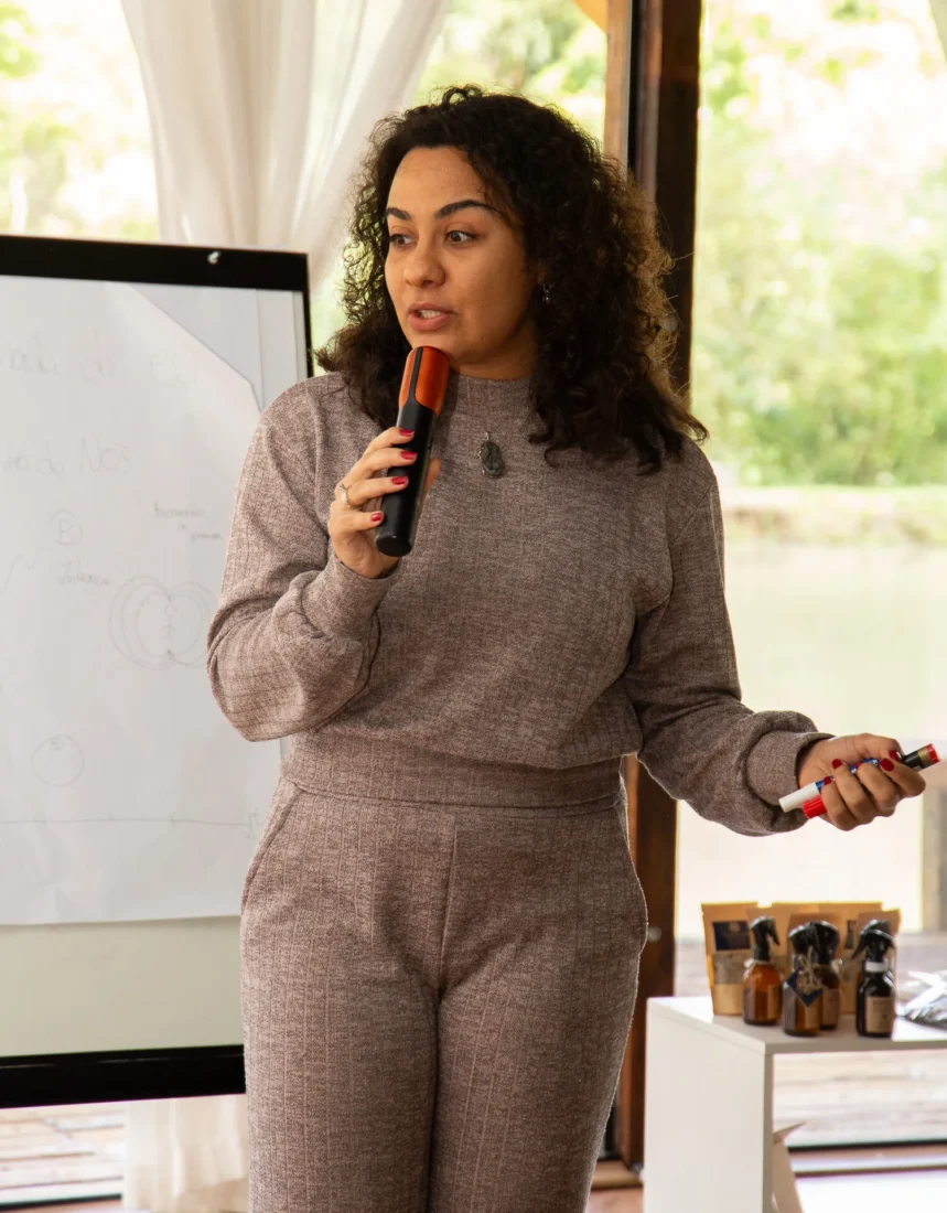 Débora Lucas palestrando em um evento corporativo, falando sobre consciência, presença e novos começos.